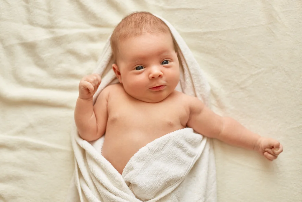 Salto de Desenvolvimento aos 2 Meses: O que Esperar e Como Acompanhar o Crescimento do Seu Bebê 2 Bebê enrolado numa toalha