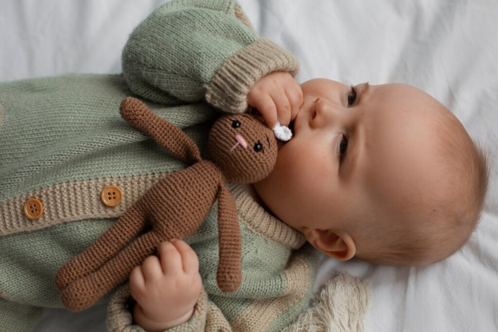 As Melhores Roupas de Inverno para Bebê: Conforto e Estilo para os Dias Frios 1 bebe fofo de vista superior com bicho de pelucia 23 2150573674
