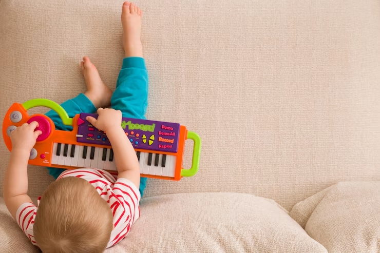 Os 10 Melhores Brinquedos Educativos para Bebês em 2025: Aprendizado e Diversão Garantidos 37 vista superior do pequeno menino bonitinho sentado no sofa e tocando no piano de brinquedo 471801 20